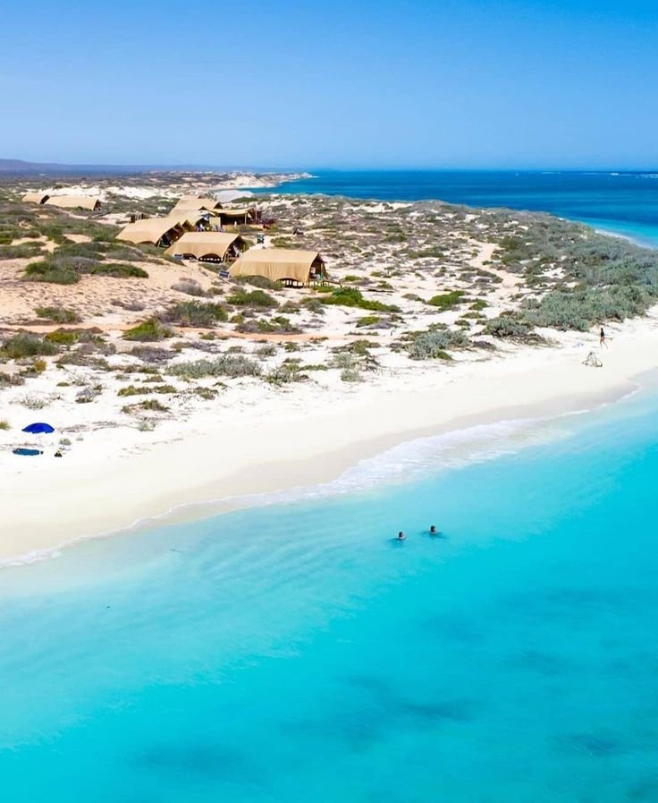 This may contain: an aerial view of a sandy beach and clear blue water in the middle of nowhere