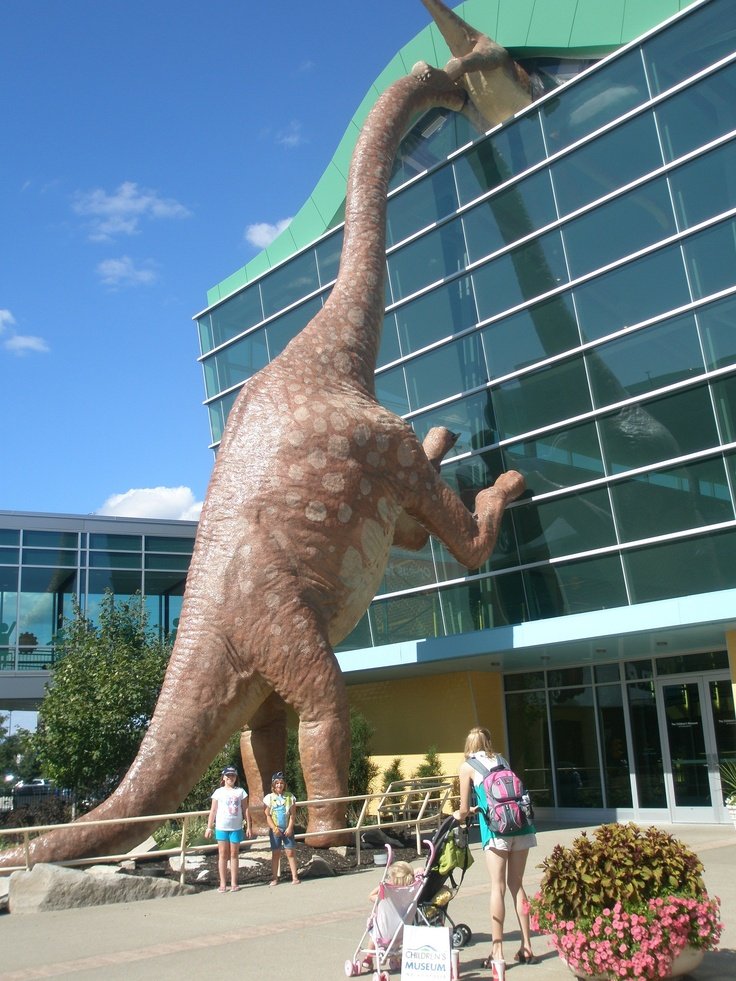 This may contain: a giant dinosaur statue in front of a building