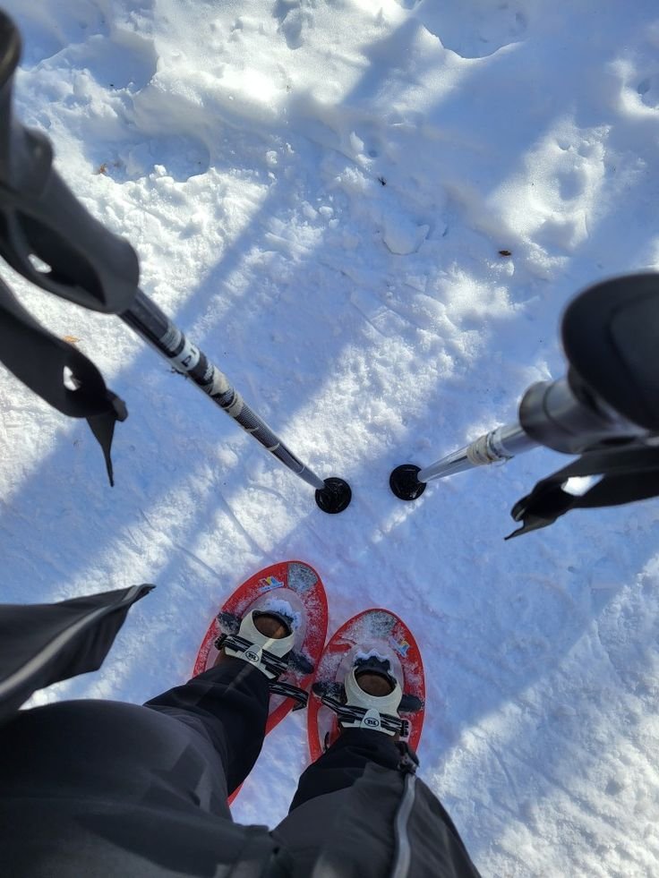 This may contain: the person is wearing skis and standing in the snow with their feet propped up