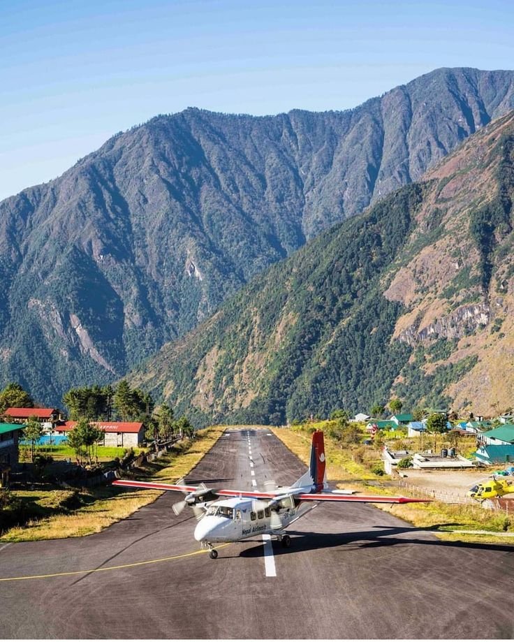 This may contain: an airplane is parked on the runway in front of mountains