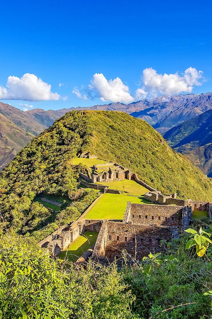 This may contain: the ruins of machaca pico are surrounded by lush green mountains and blue skies