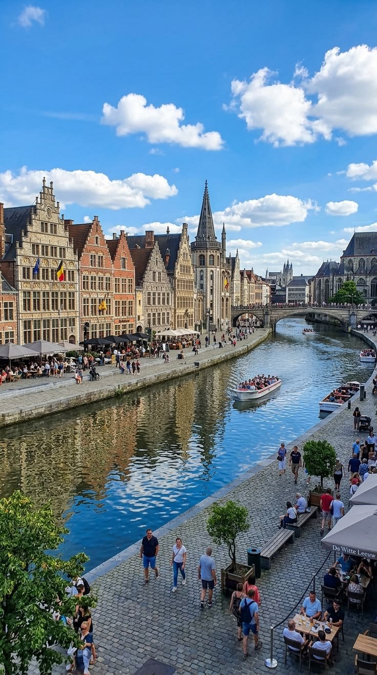 This may contain: people are walking along the river in an old european city with many buildings on either side