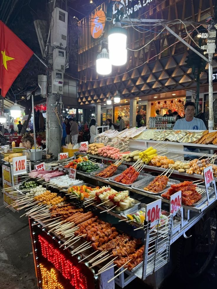 This may contain: an outdoor food stand with various foods on skewers