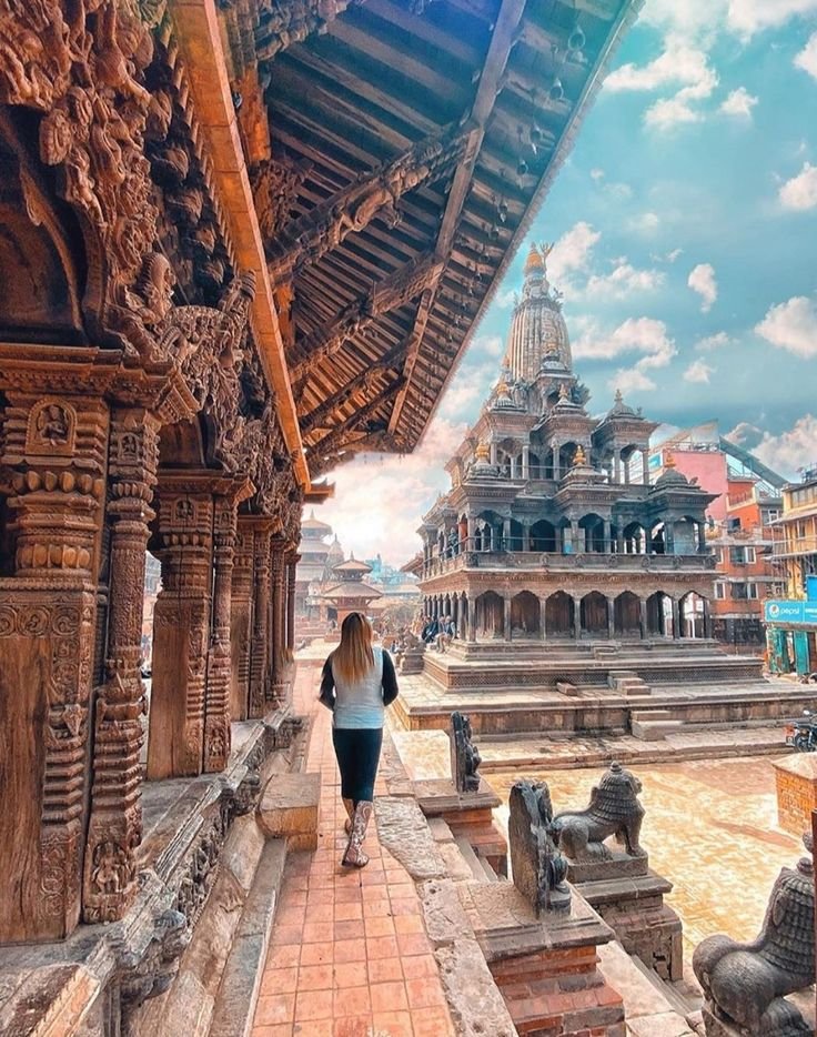 This may contain: a woman is walking down the walkway in front of an ornate building with columns and arches