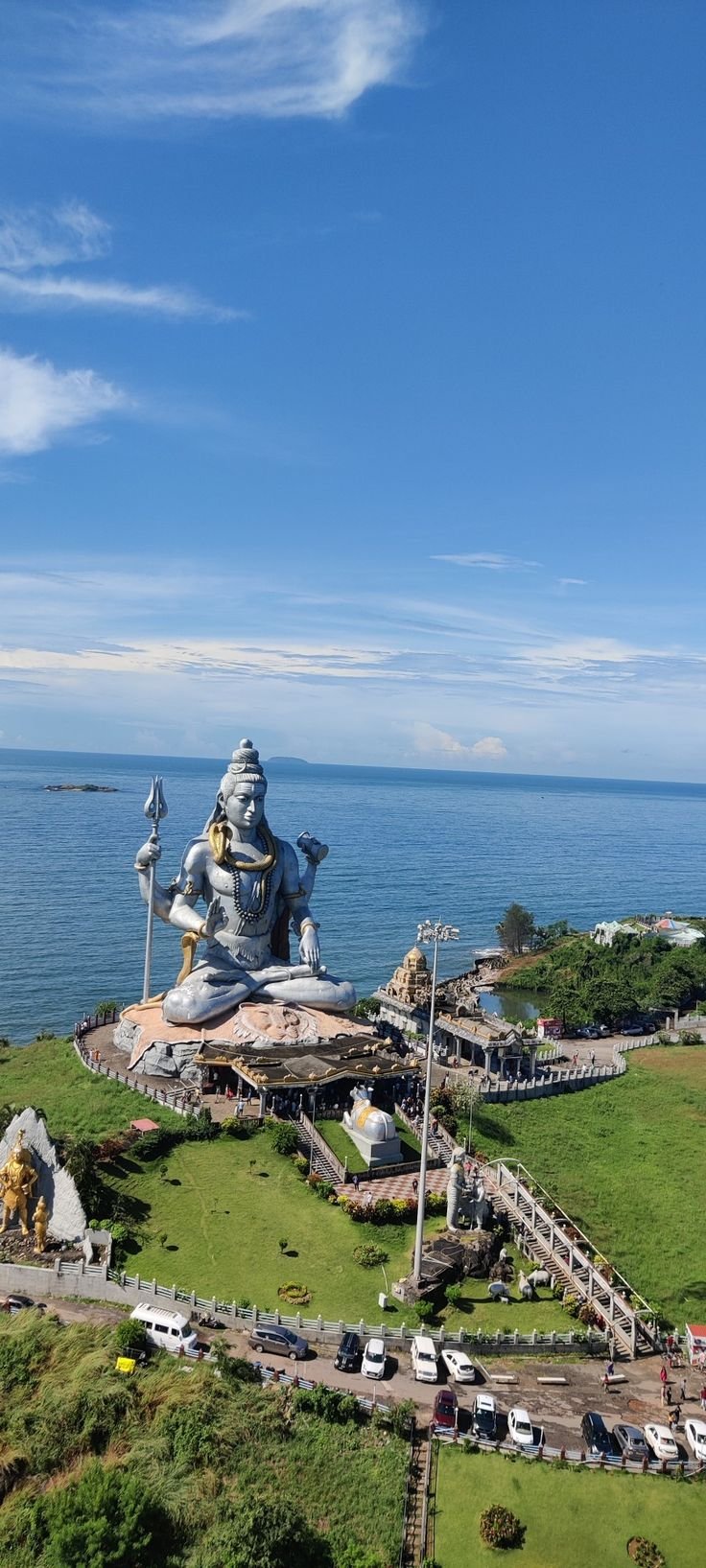 This may contain: an aerial view of a large statue in the middle of a grassy area next to the ocean