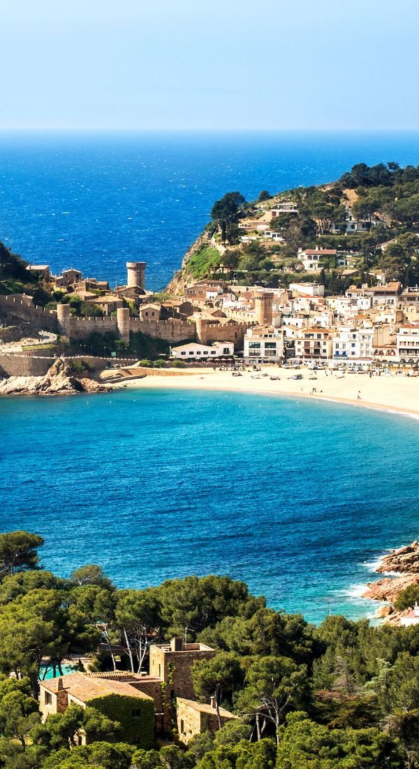 This may contain: an aerial view of the beach and town from above, with blue water in the foreground