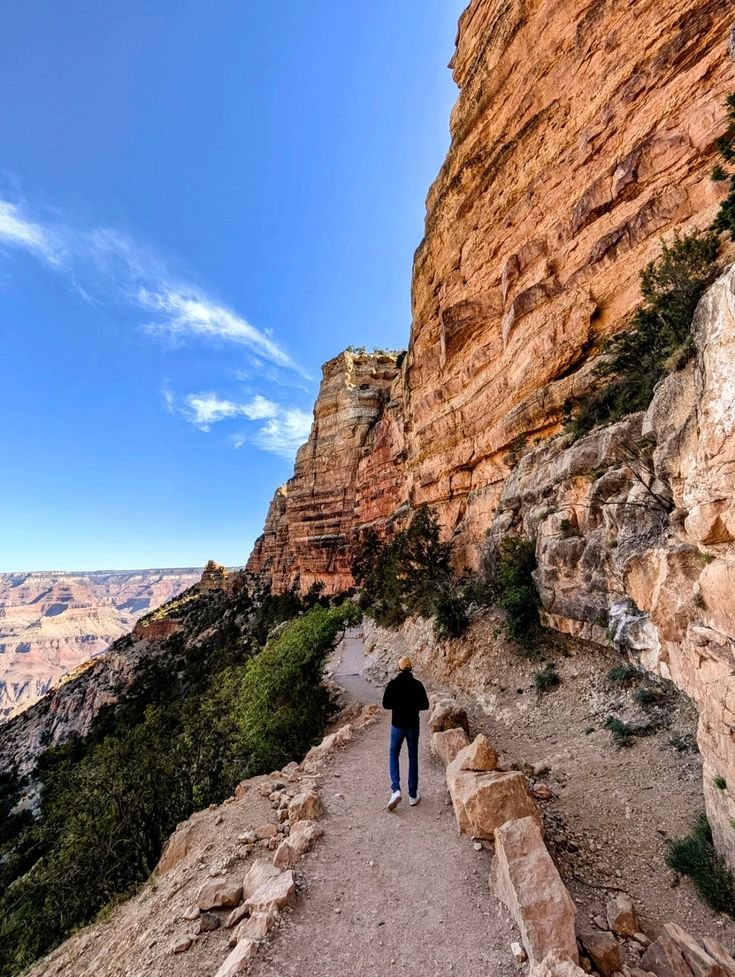 This may contain: a man standing on the edge of a cliff