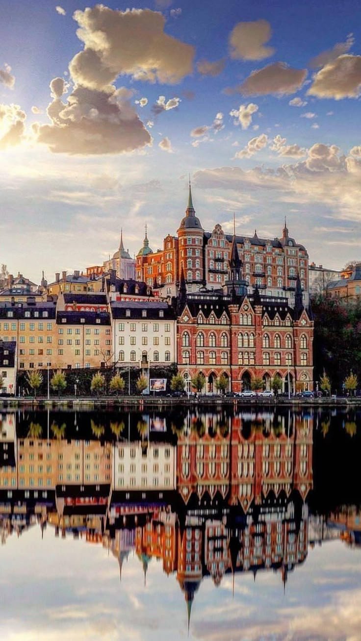 This may contain: the buildings are reflected in the still water