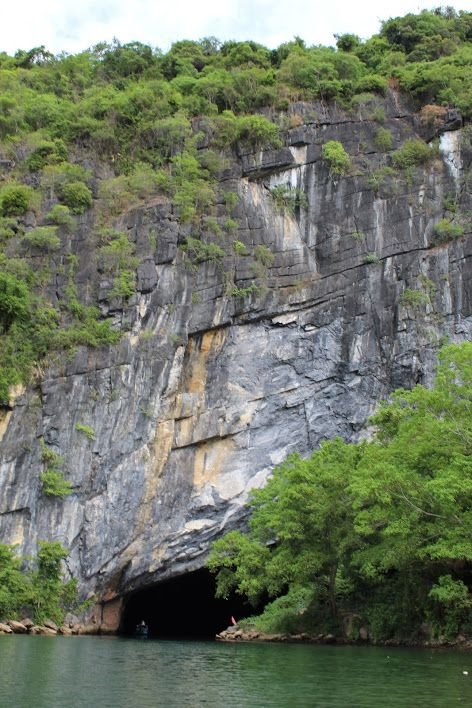 This may contain: there is a cave in the side of this mountain