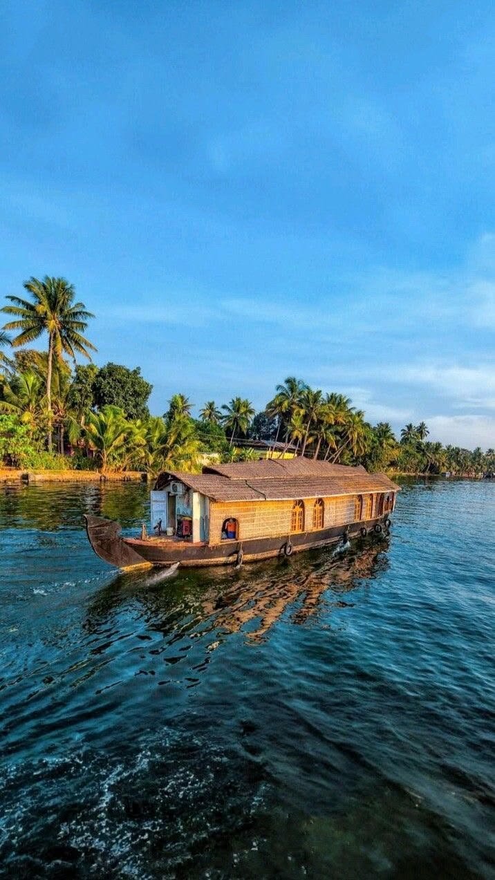 This may contain: a small house boat on the water with palm trees in the background