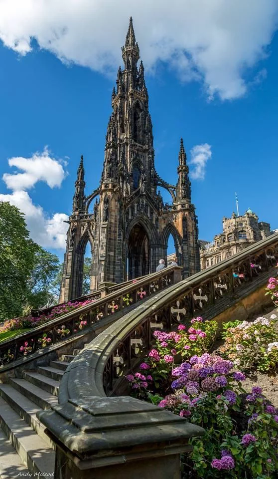 This may contain: the stairs lead up to an ornate building with flowers growing on it's sides