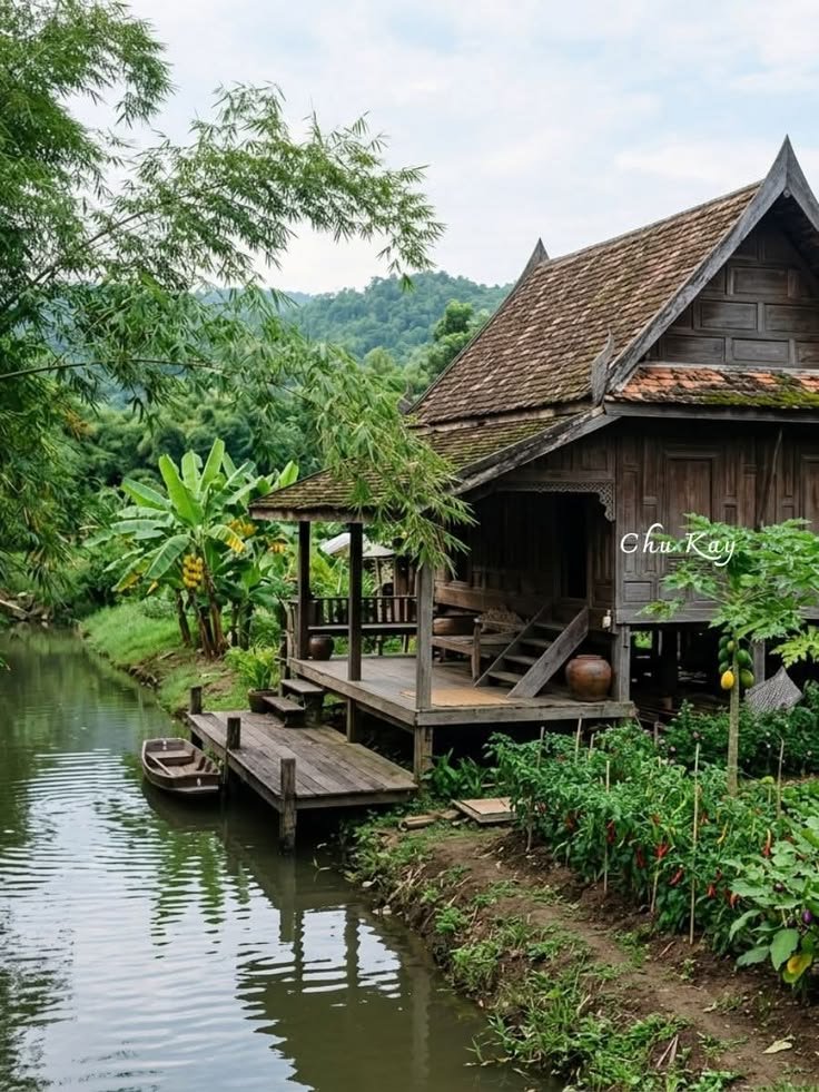 This may contain: a wooden house sitting on the side of a river
