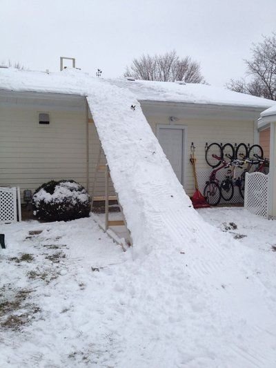 This may contain: a house that has been completely covered in snow with bikes parked on the side of it