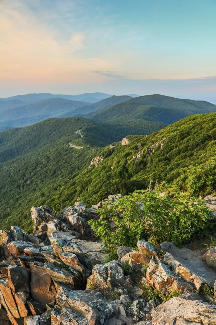 This may contain: the mountains are covered with rocks and greenery