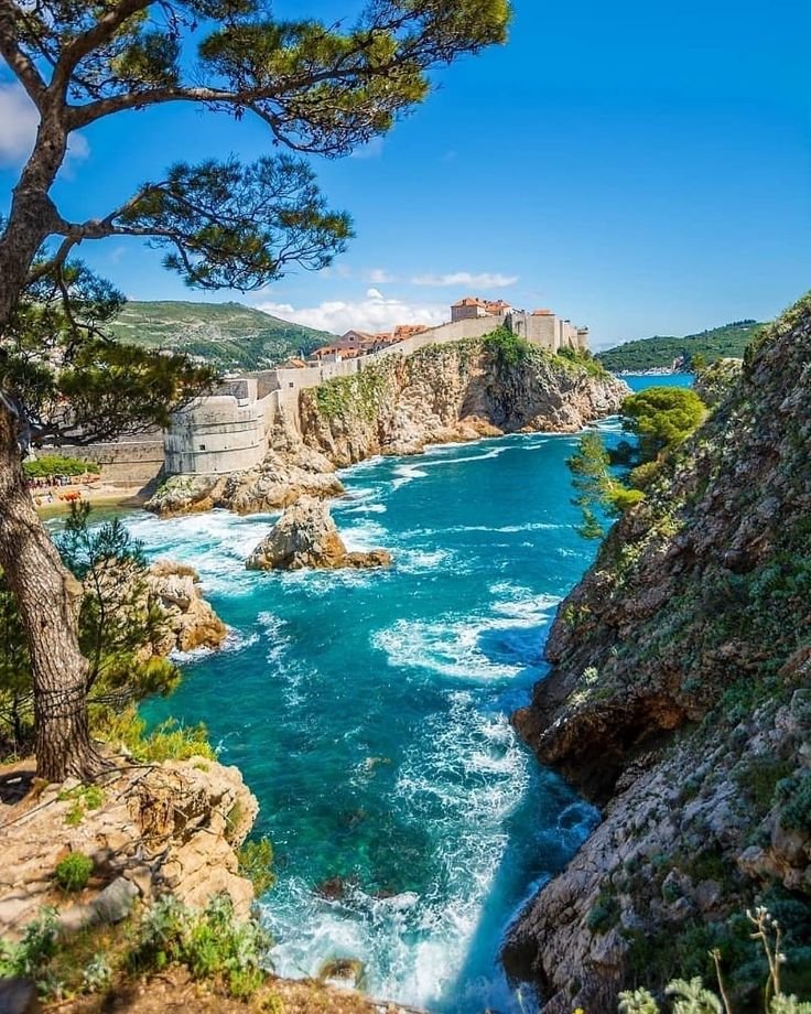This may contain: the water is very blue and clear in this view from an overlook point on top of a cliff