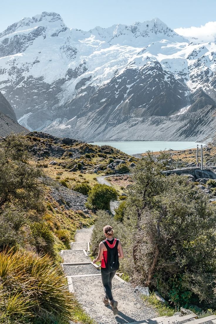 This may contain: a woman is walking up some stairs in the mountains