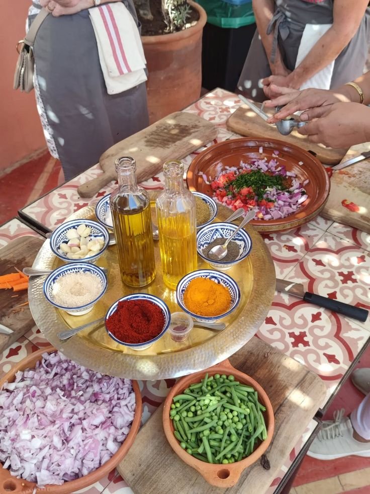 This may contain: people standing around a table with bowls and plates of food on it, including vegetables