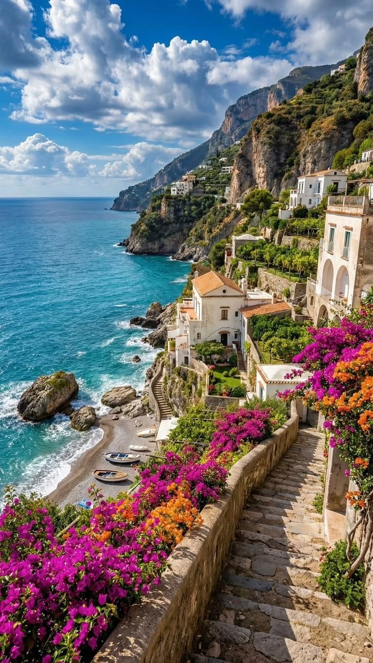 This may contain: stairs leading down to the beach with colorful flowers growing on them and water in the background
