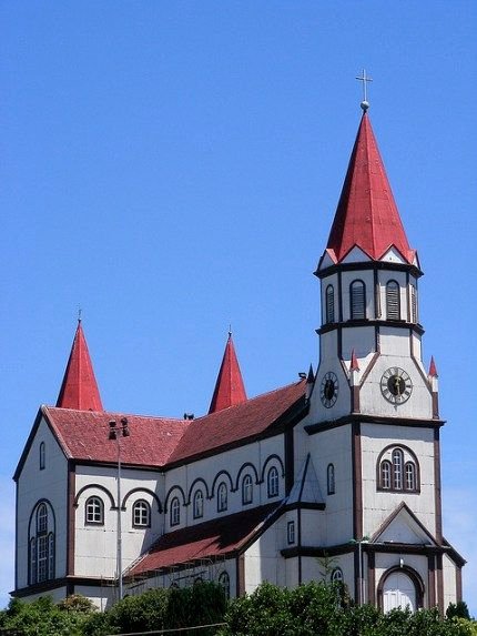This may contain: an old church with red roof and steeples