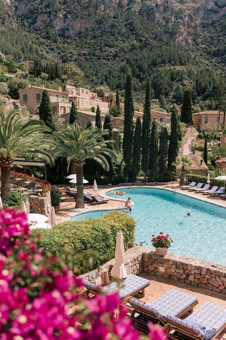 This may contain: an outdoor swimming pool with chaise lounges next to it