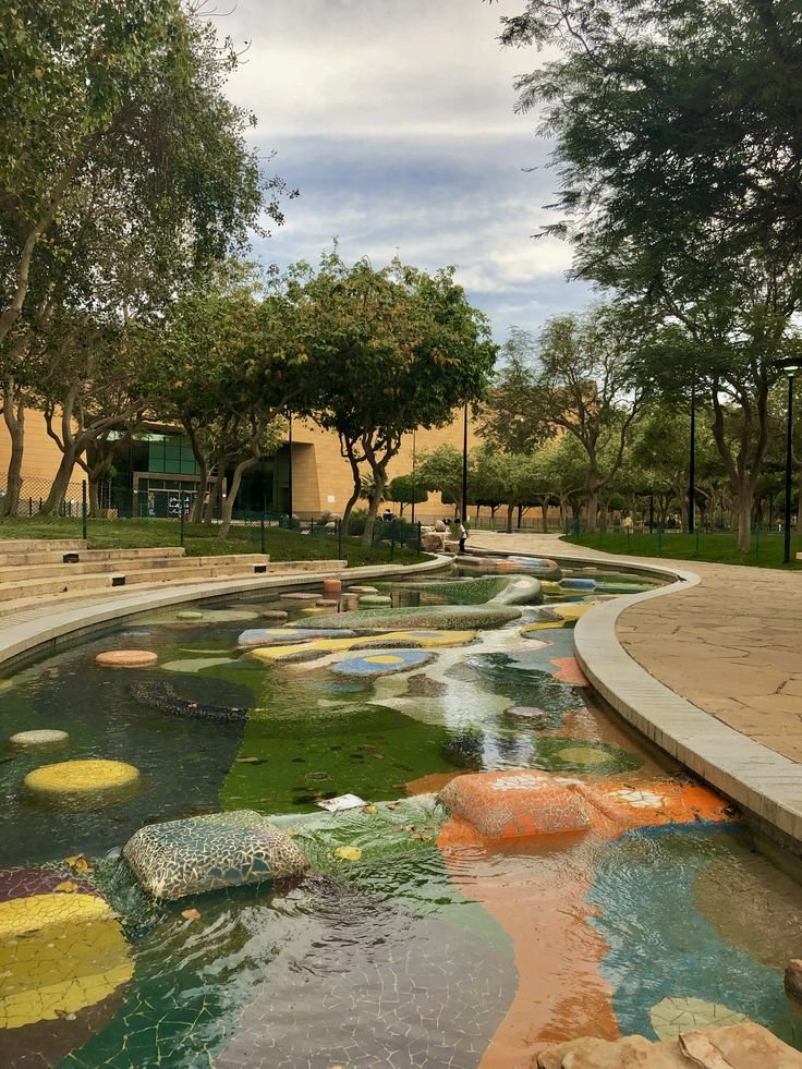 This may contain: a large pond filled with lots of colorful rocks