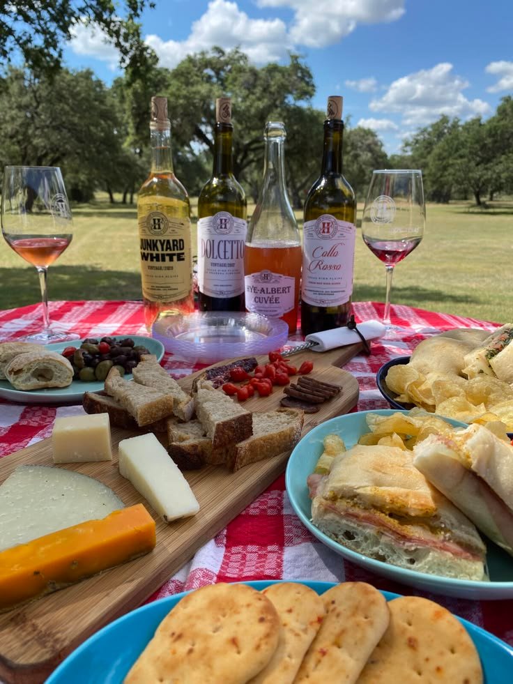 This may contain: a table topped with plates of food and bottles of wine