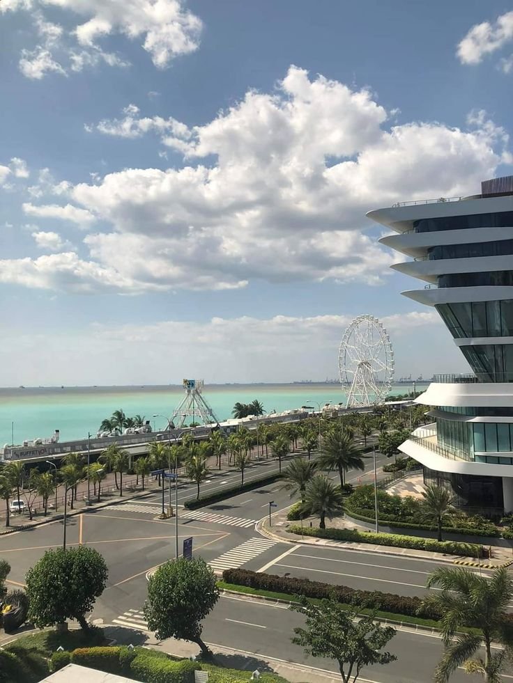 This may contain: an aerial view of a ferris wheel and the beach in front of a large building