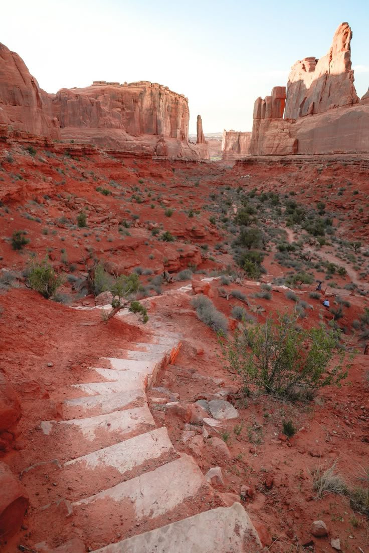This may contain: there is a stone path in the middle of the desert with steps leading up to it