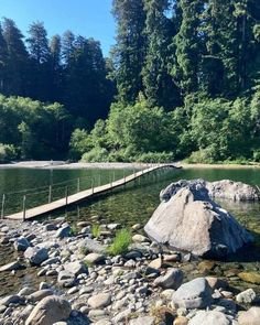 This may contain: there is a large rock in the middle of the water and some rocks on the shore