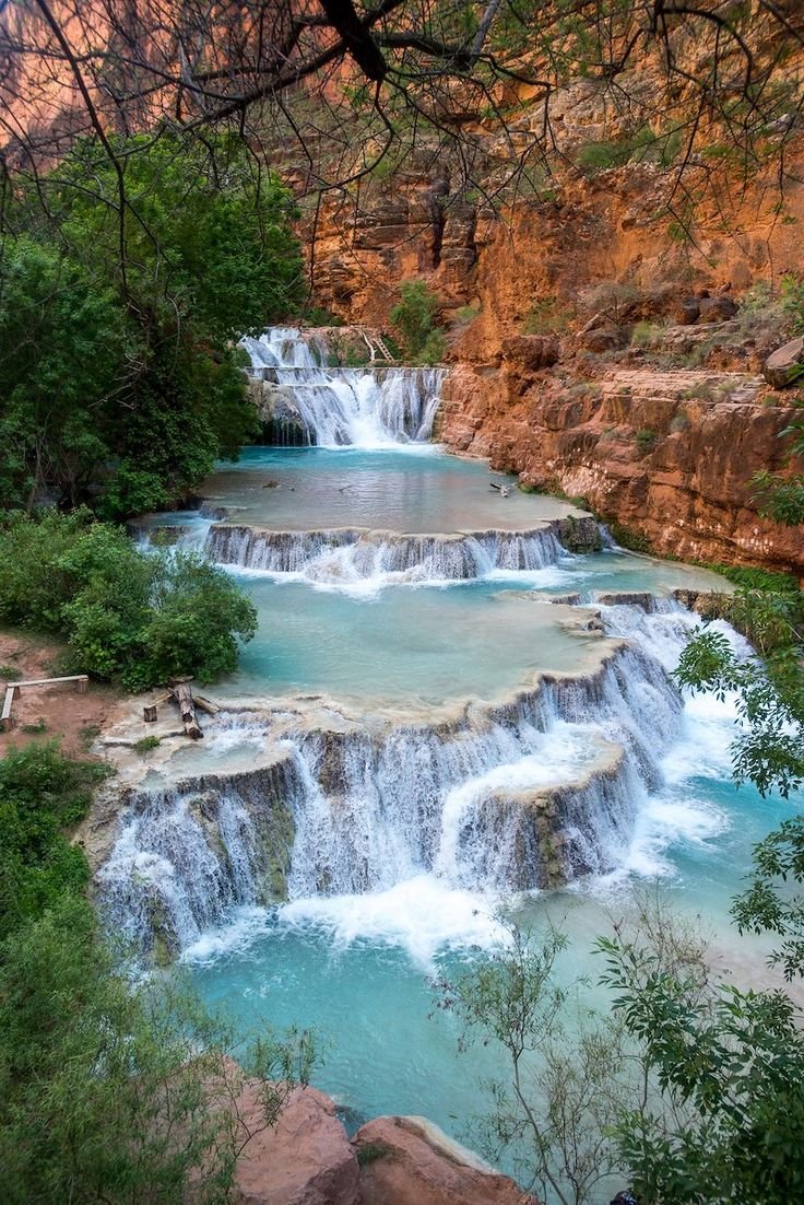 This may contain: the waterfalls are flowing into the blue water