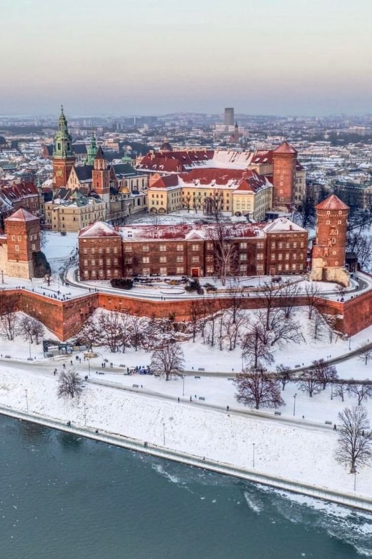 This may contain: an aerial view of a large building in the middle of a river and snow covered ground