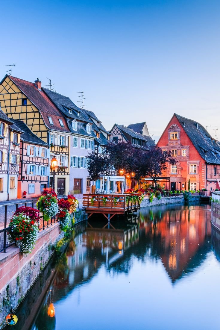 This may contain: a river running through a small town with lots of buildings on the side of it