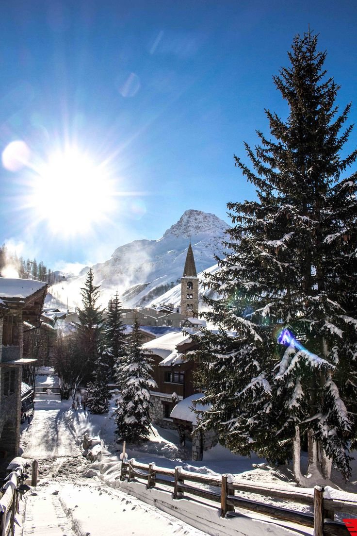 This may contain: the sun shines brightly over a snowy village