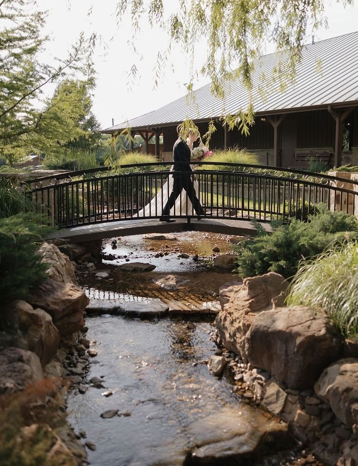 This may contain: a man walking across a bridge over a creek