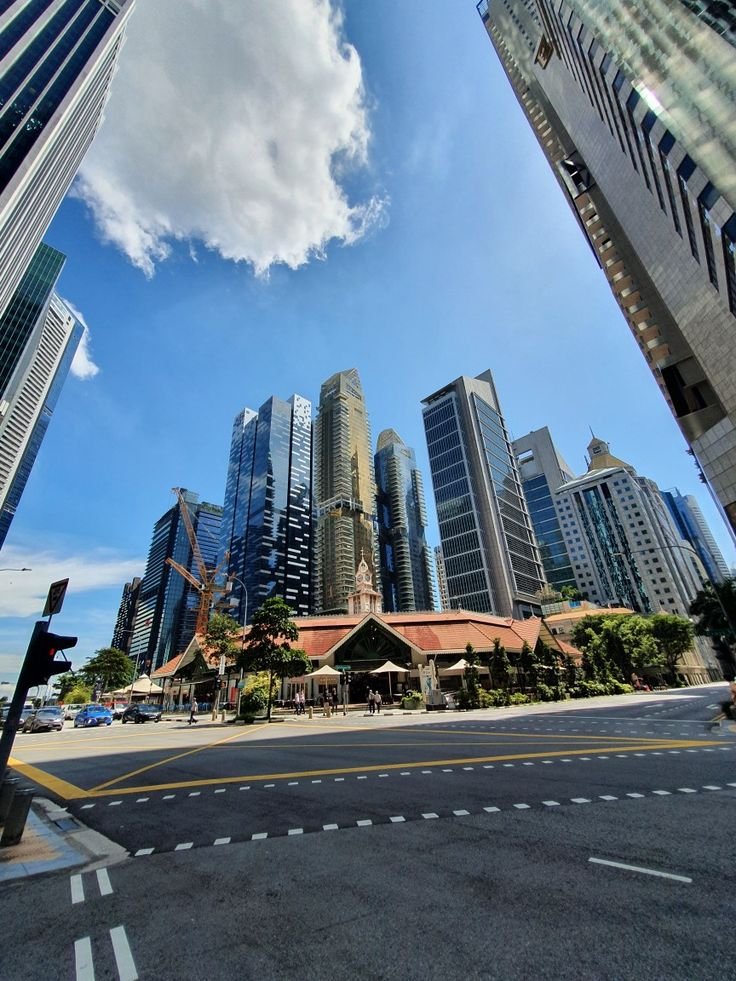 This may contain: the city is full of tall buildings and high rise skyscrapers as seen from across the street