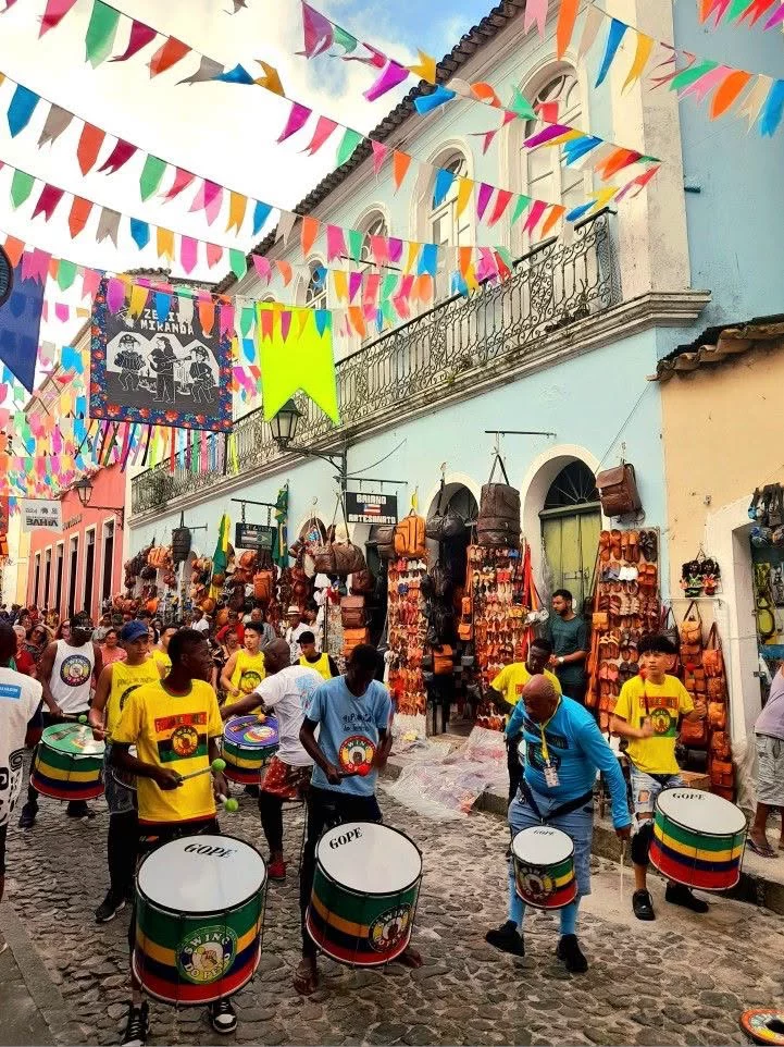 This may contain: a group of people playing drums in the street