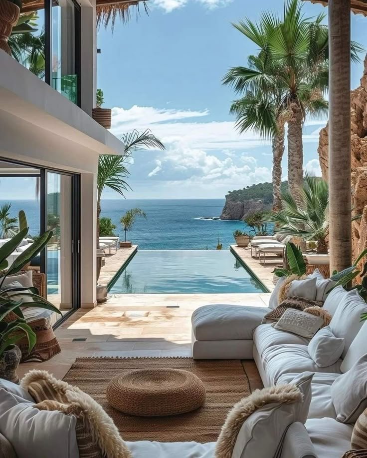 This may contain: a living room filled with lots of furniture next to a swimming pool and palm trees