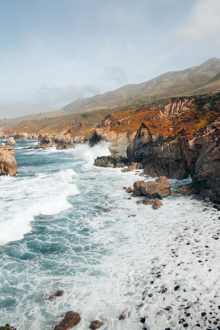 This may contain: an ocean view with waves crashing on the rocks