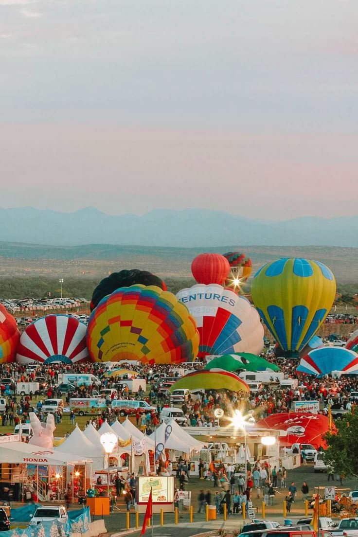 This may contain: many hot air balloons are in the sky