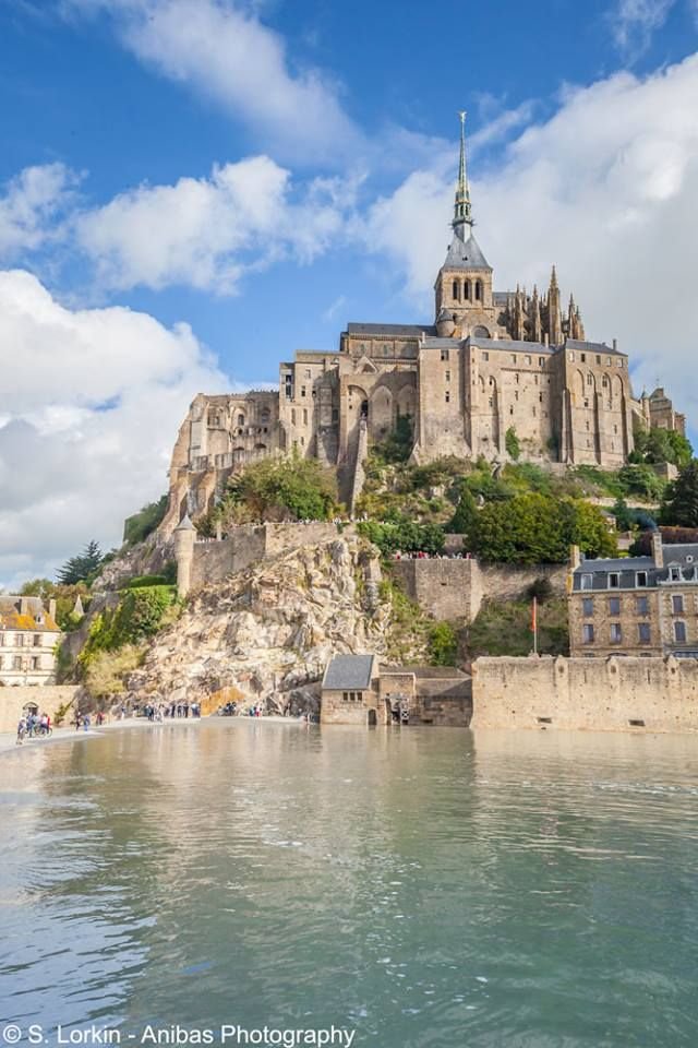 This may contain: an old castle sitting on top of a hill next to the ocean