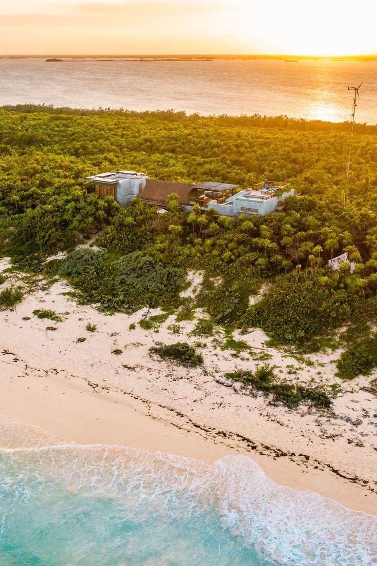 This may contain: an aerial view of the beach and ocean at sunset