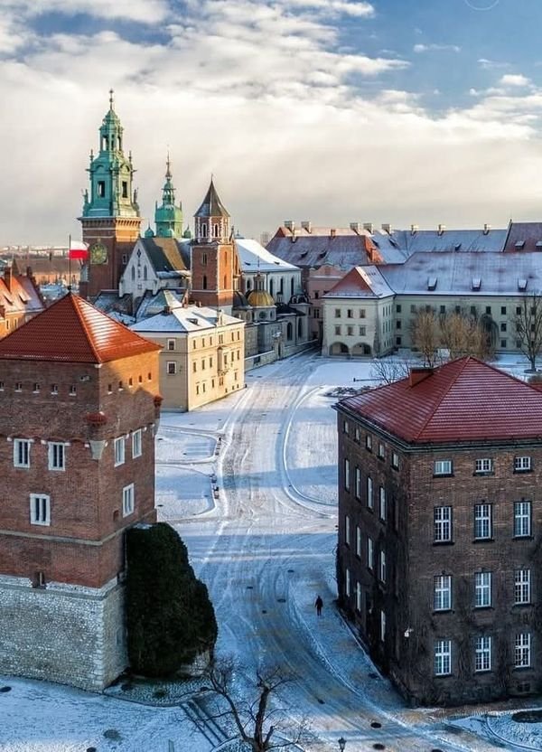 This may contain: an aerial view of a city with buildings in the foreground and snow on the ground