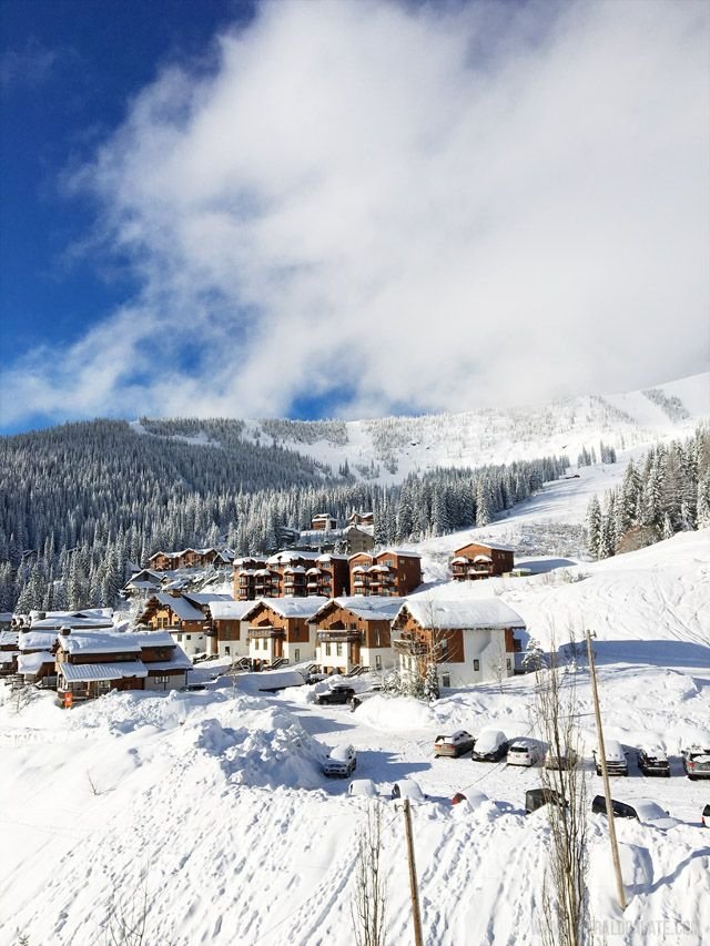This may contain: a snow covered ski slope with houses on it