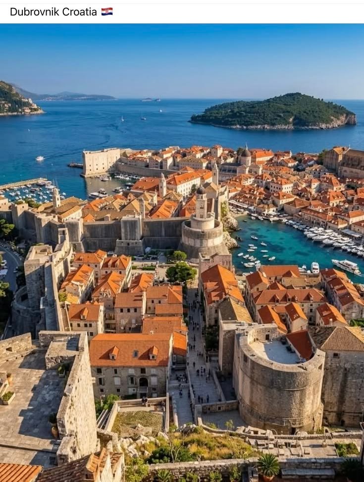 This may contain: an aerial view of dubunnik croatia with boats in the water and red roofs