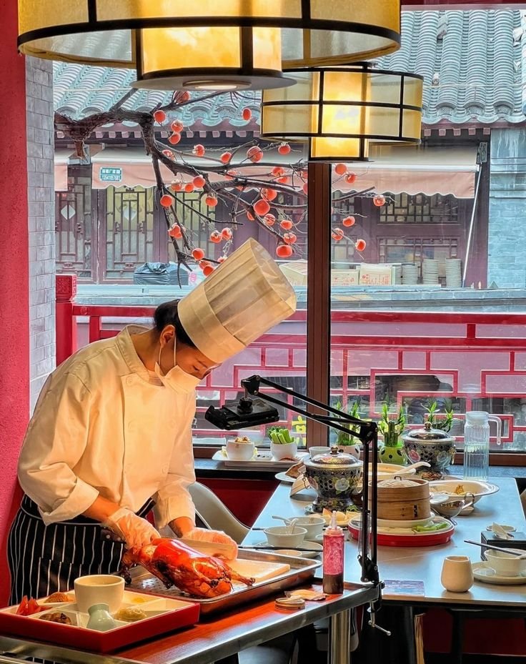 This may contain: a chef is preparing food on a tray in front of a window at a restaurant