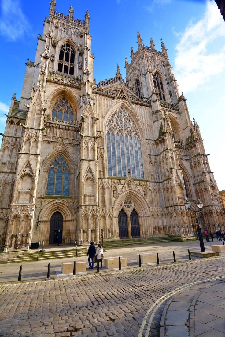 This may contain: two people standing in front of a large cathedral