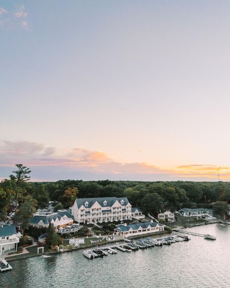 This may contain: an aerial view of boats in the water and houses on the other side of the lake