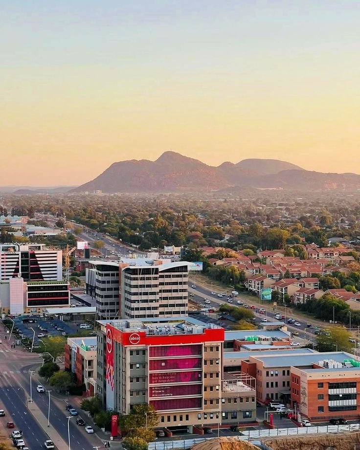 This may contain: an aerial view of a city with mountains in the background
