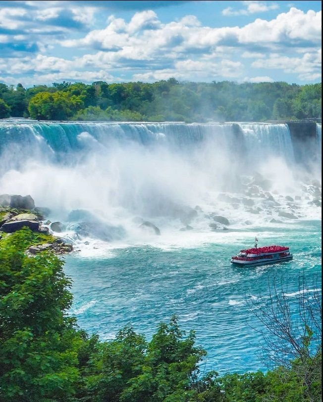 This may contain: a boat in the water near a waterfall