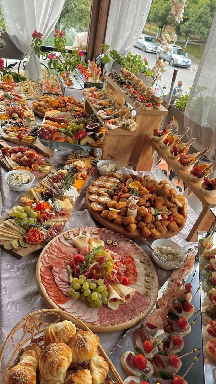 This may contain: a buffet table filled with lots of different types of food on plates and trays